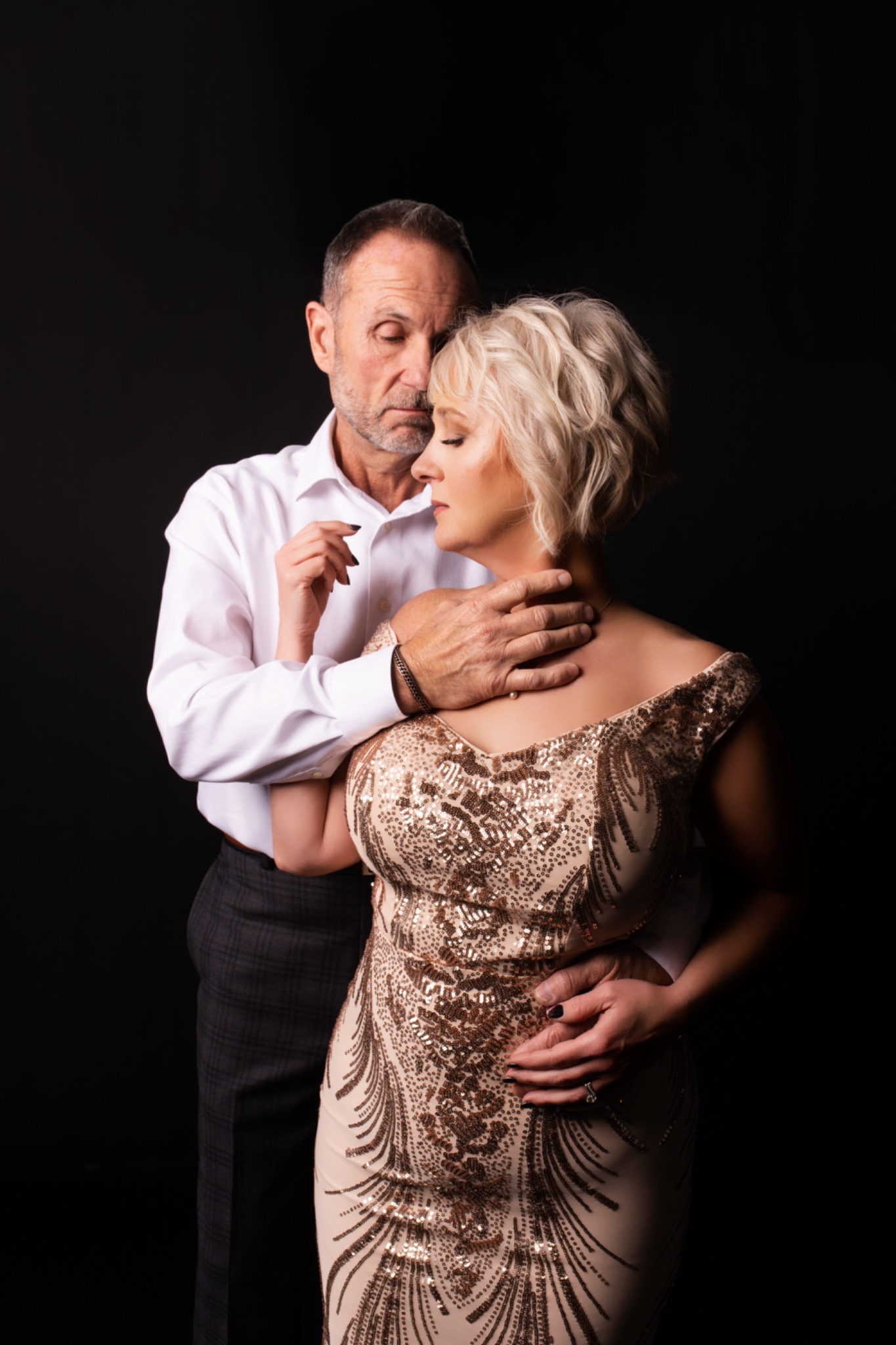 Couple sharing a close moment in a gold gown and white shirt