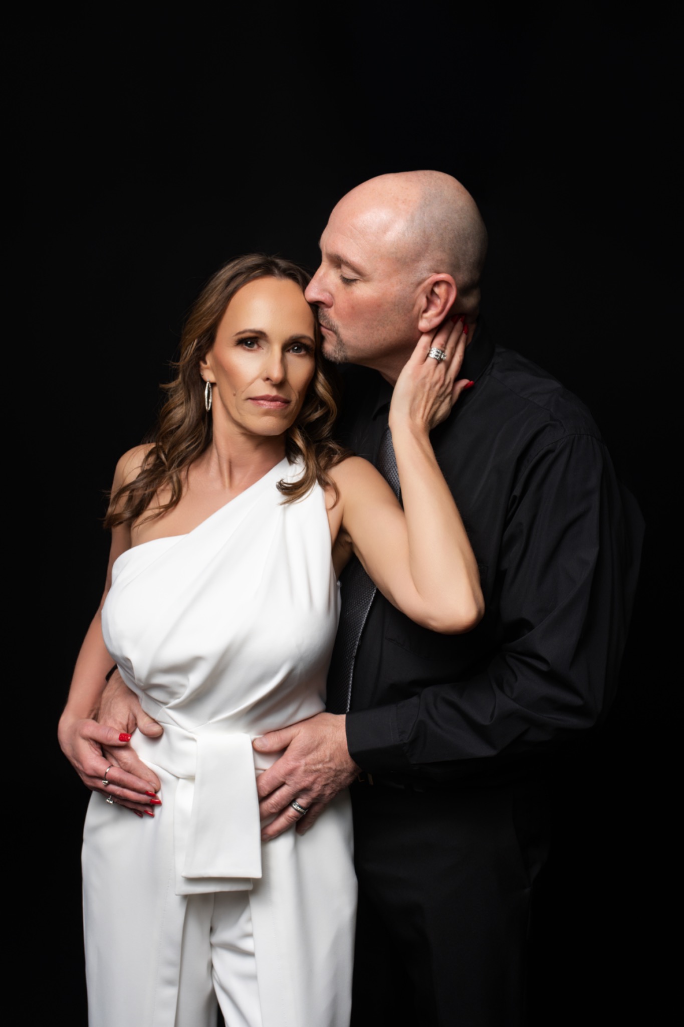 Couple sharing a tender moment in a white gown and black shirt