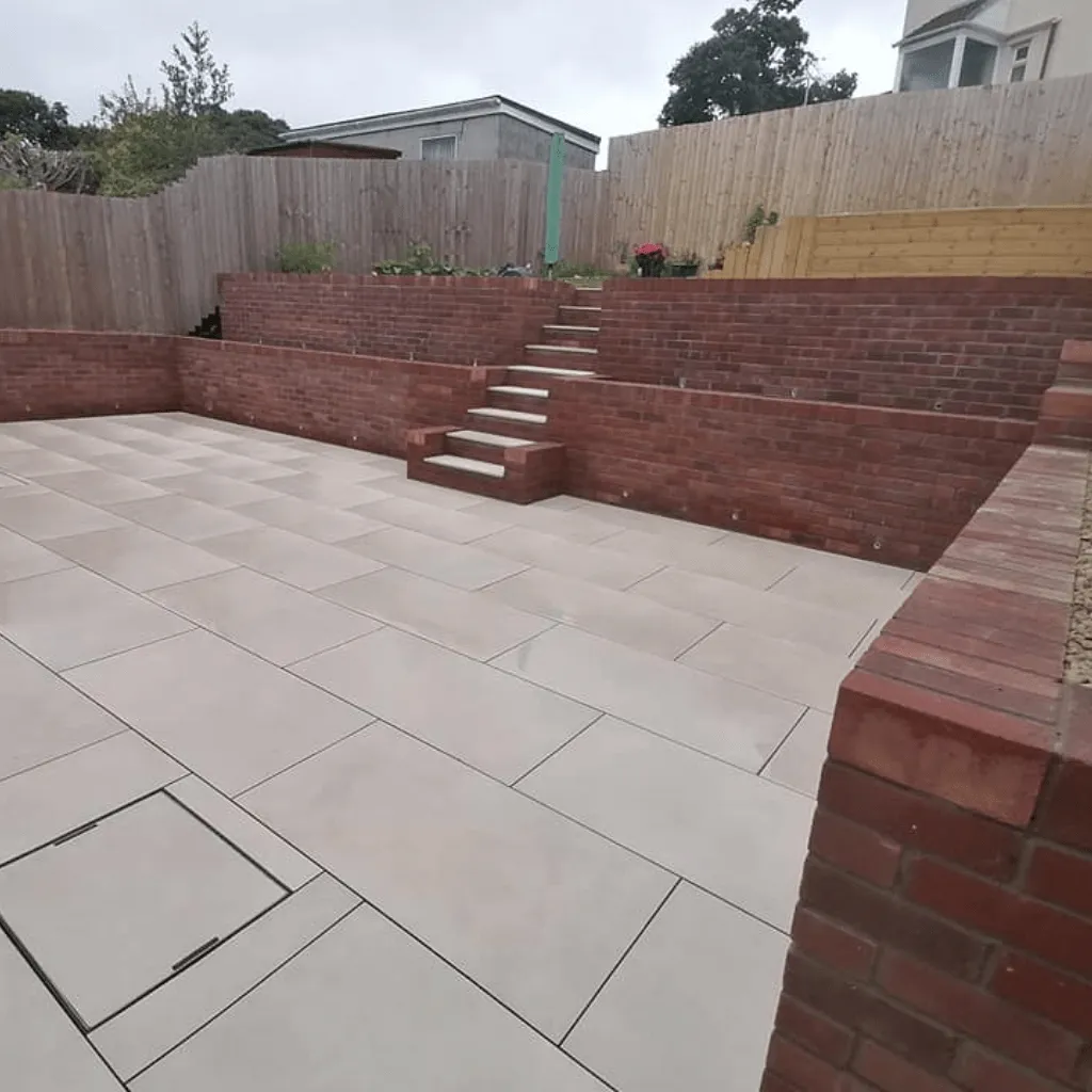 Large patio that runs up steps into another garden