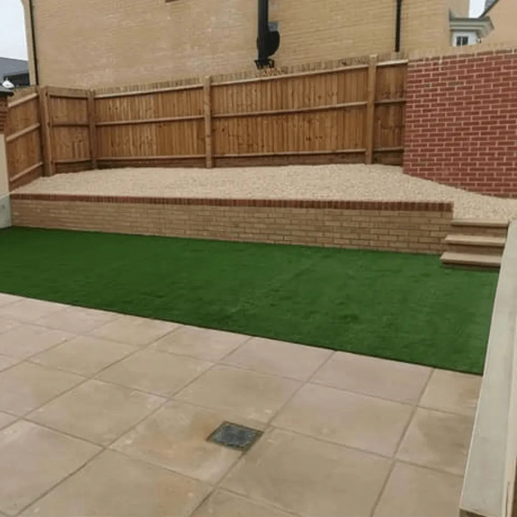 Square tiled patio and artifical grass that have been laid in Cardiff.