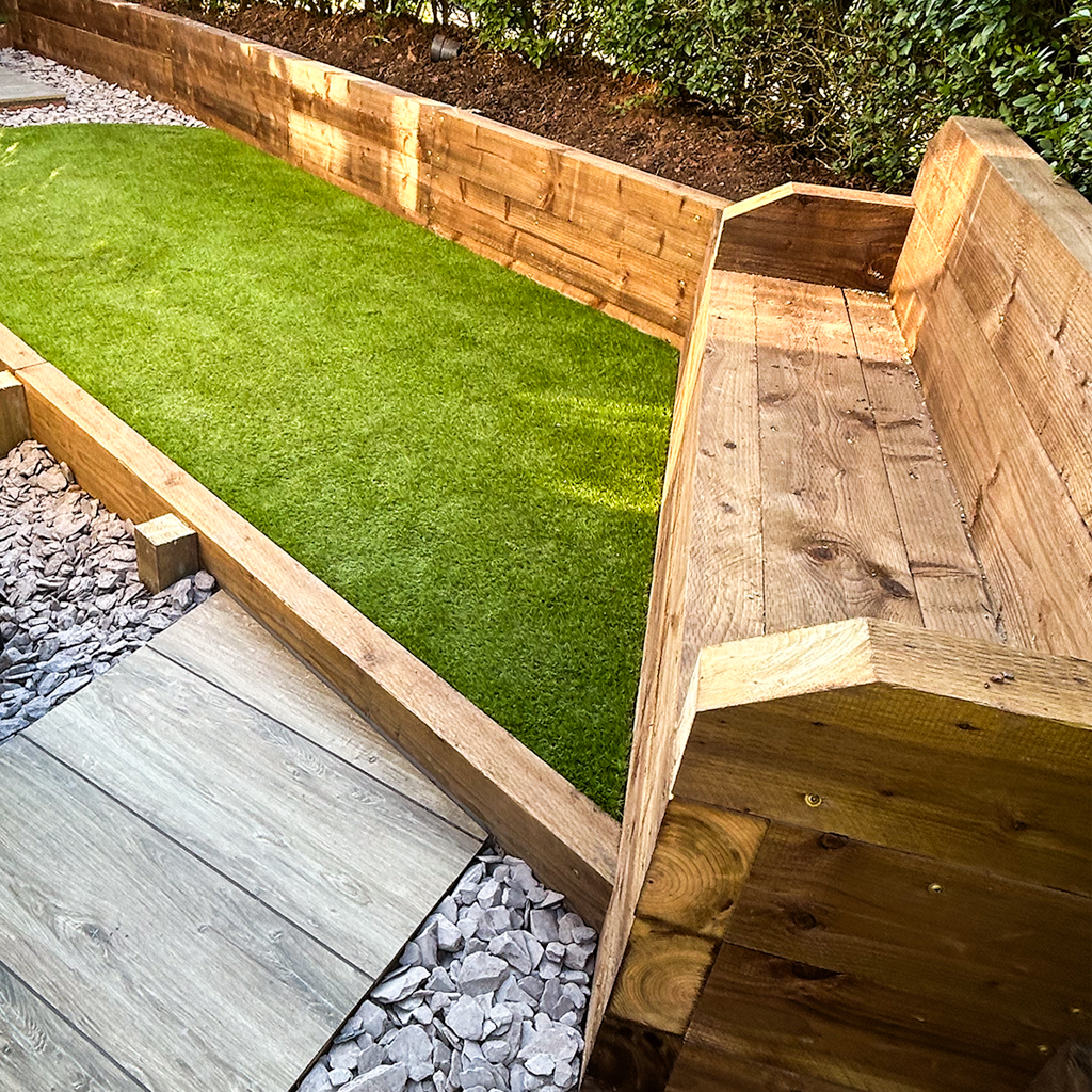 Wooden sleepers and a light grey patio that our landscapers installed in a back garden.