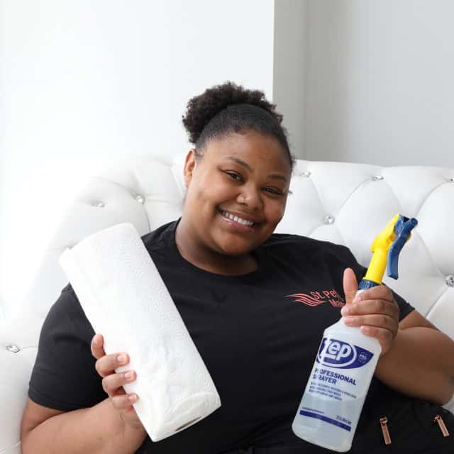 cleaner holding paper towels and spray bottle