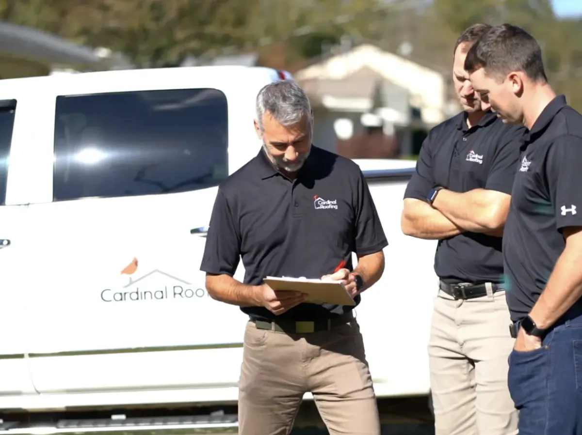 A wooden roof with decorative ornament against blue sky.