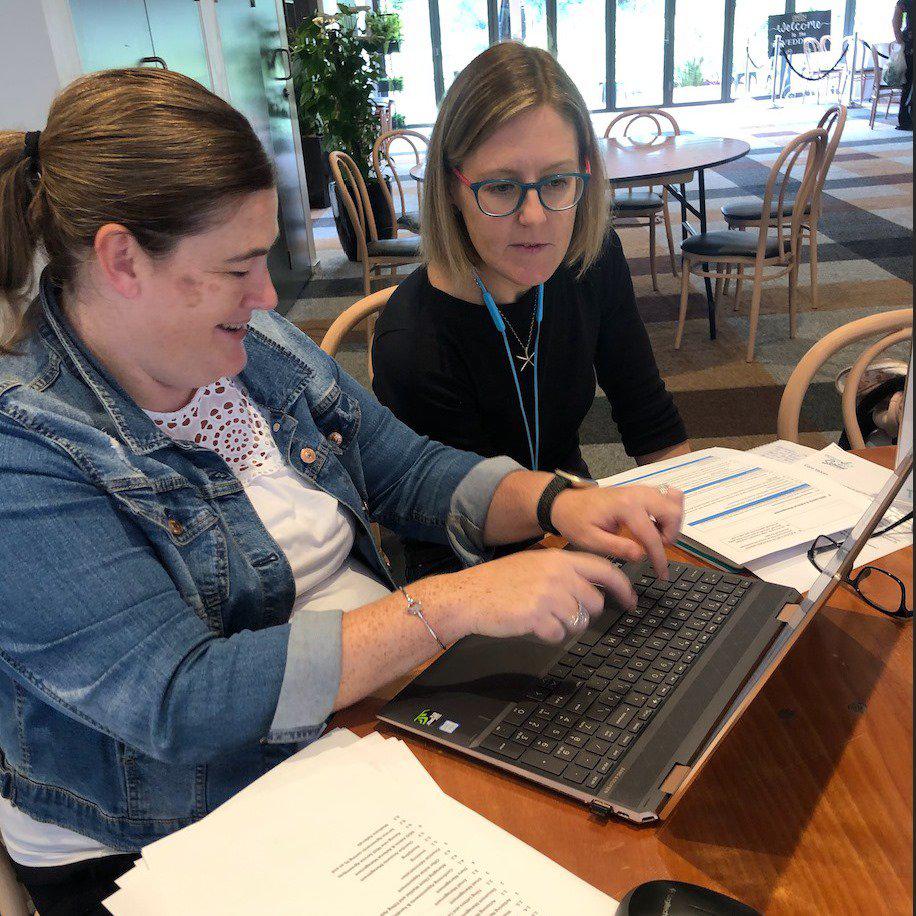 Positively Sorted team working on laptop in cafe
