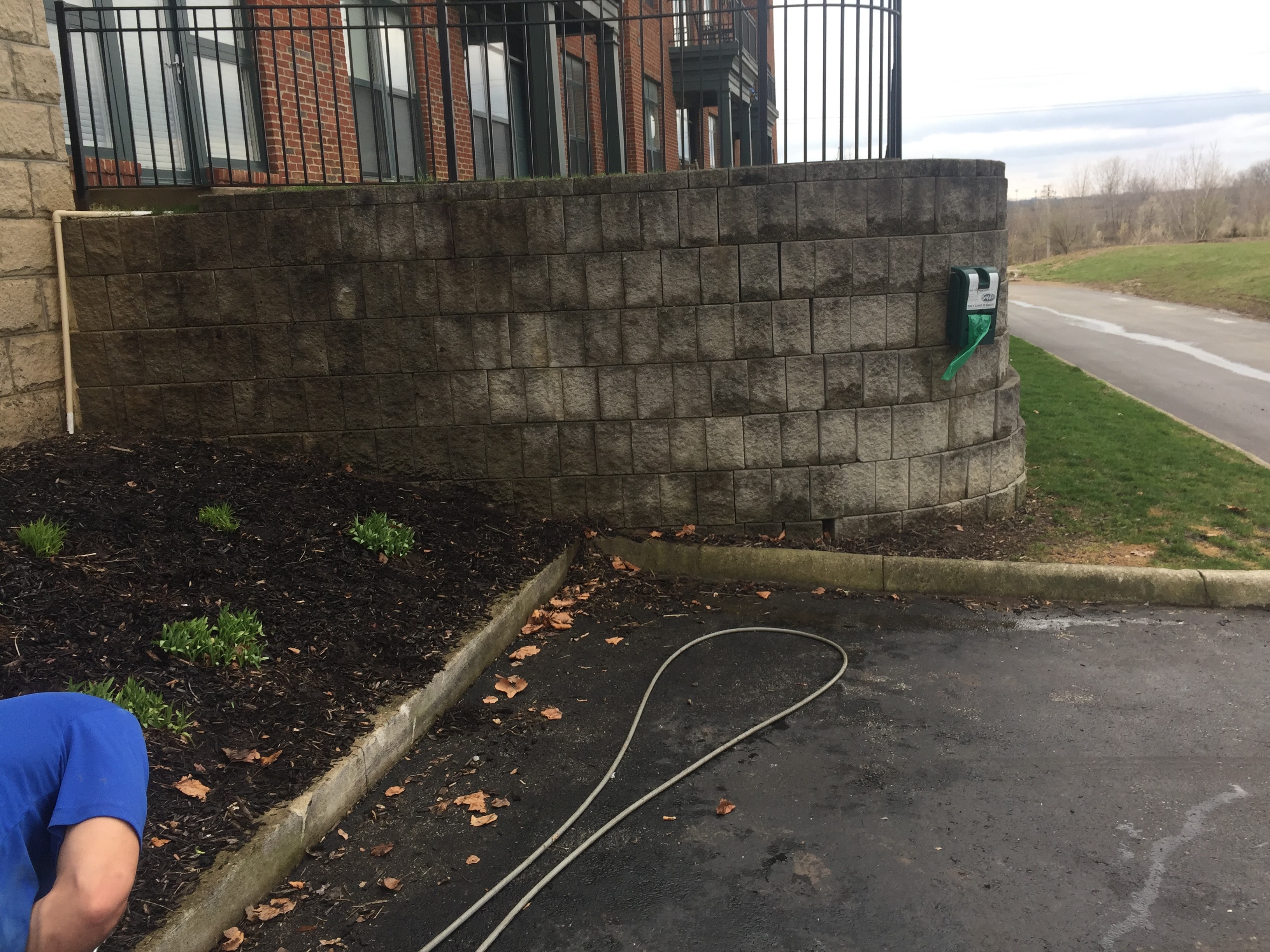Commercial paver and foundation wall before exterior cleaning – Missions Pressure Washing service example