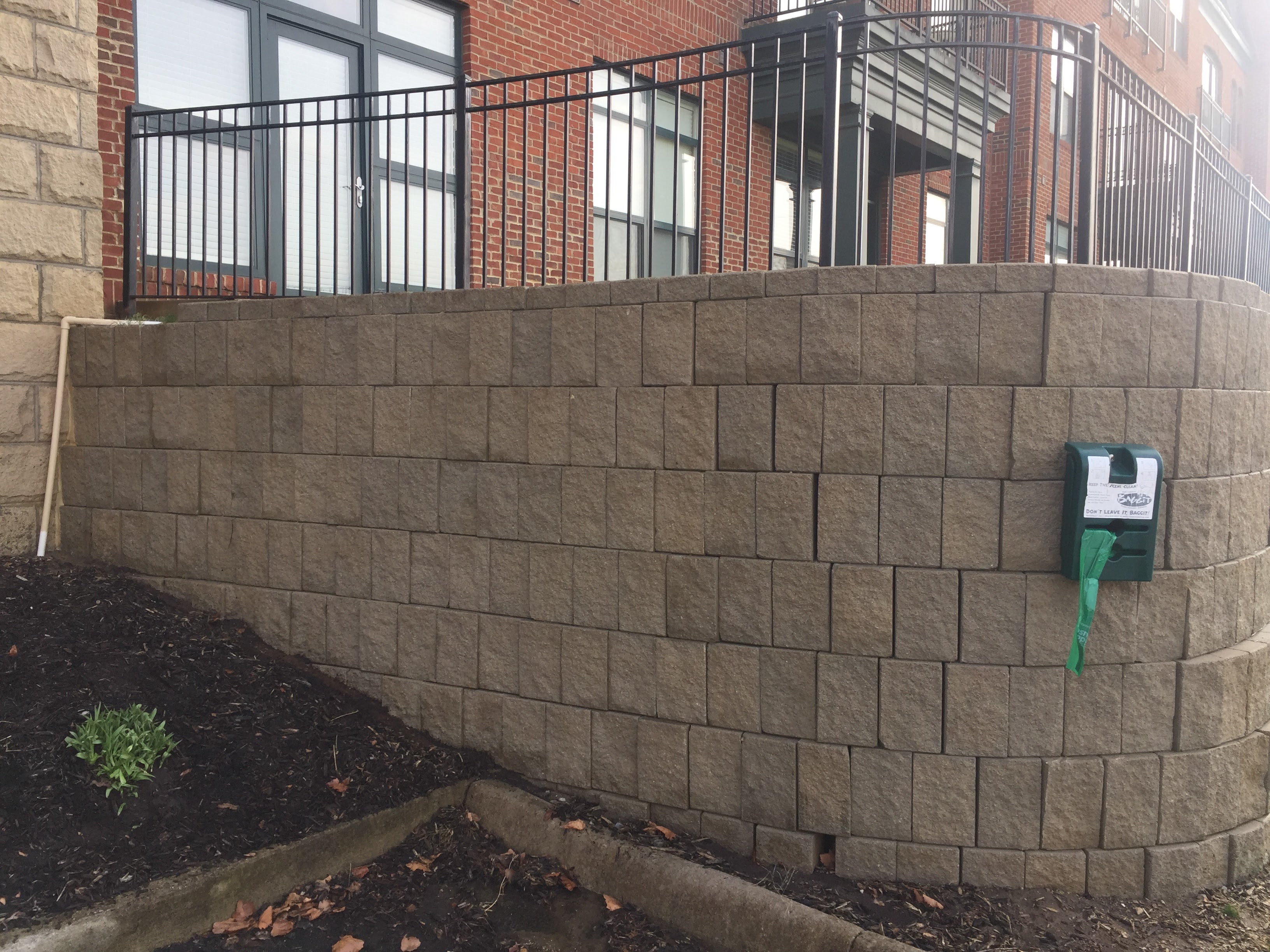 Commercial paver and foundation wall after exterior cleaning – Missions Pressure Washing service example