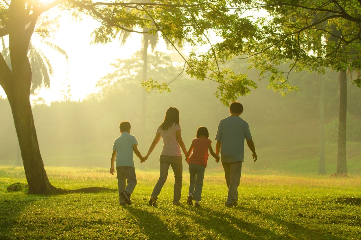 family walking through a meadow in the sunshine