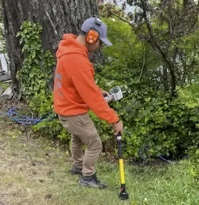 Plumber using leak detection equipment to locate underground water line issue