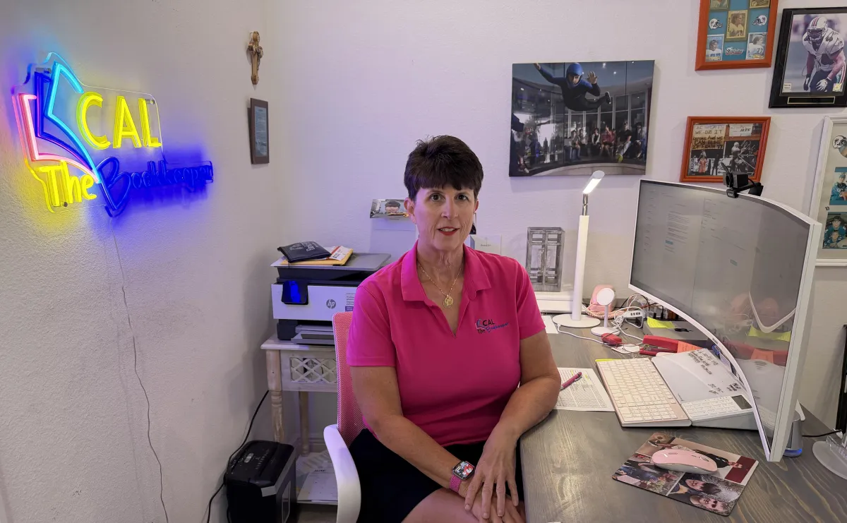 Small business owner in Clermont, Florida, working on financial documents at a cozy desk