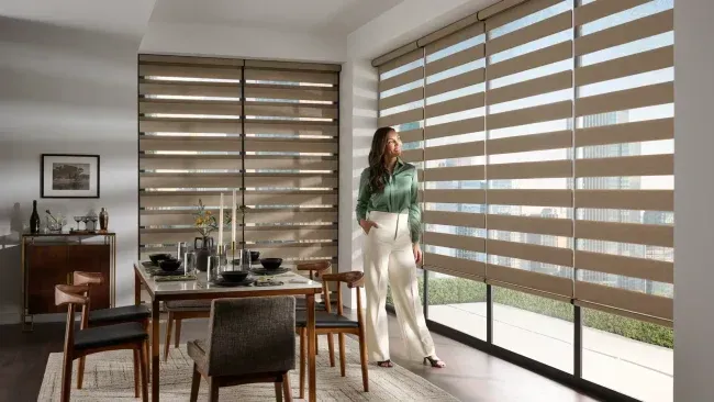 Brown zebra shades installed across large dining room windows