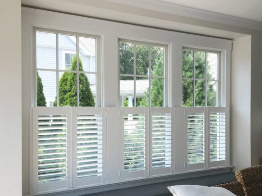 Café style shutters installed across three tall residential windows