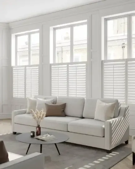 Café shutters allowing natural light above a bright living room sofa