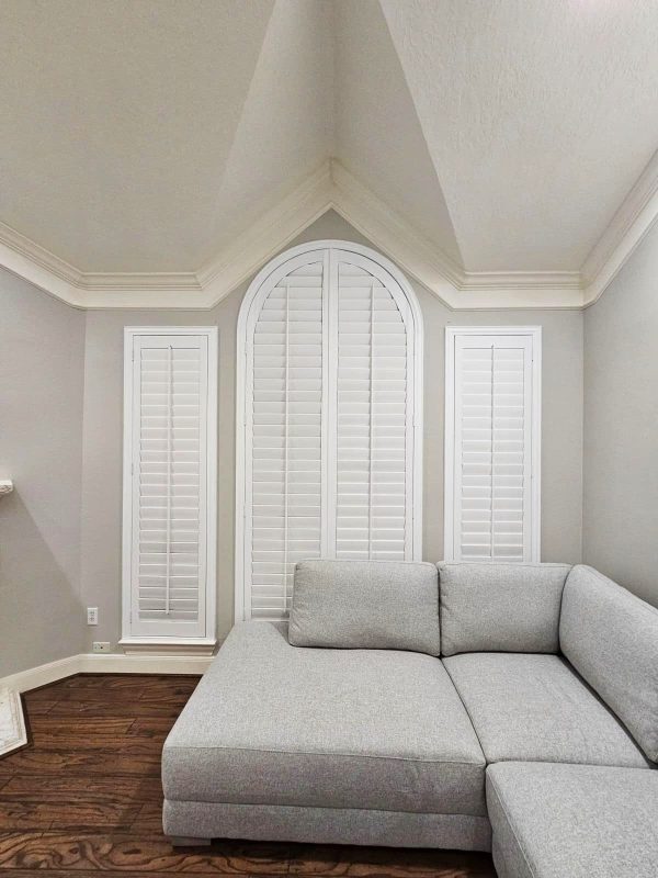 Custom plantation shutters fitted to an arched feature window
