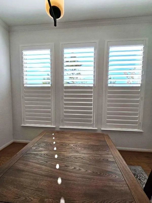 Full height plantation shutters installed across three front windows