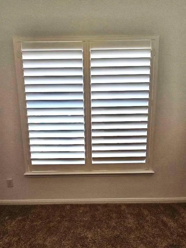 Close-up of white plantation shutters with adjustable louvers