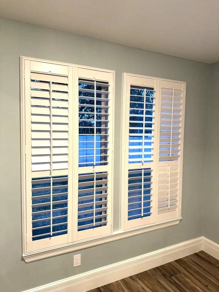 White plantation shutters installed across four adjacent windows
