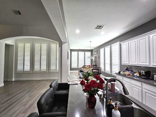 White plantation shutters installed along a bright modern kitchen
