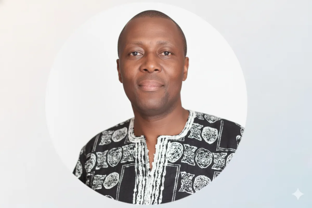 Prof. Moses Makgato, a middle-aged South African man in a smart blazer, smiling confidently in a bright office setting with books and property models in the background.