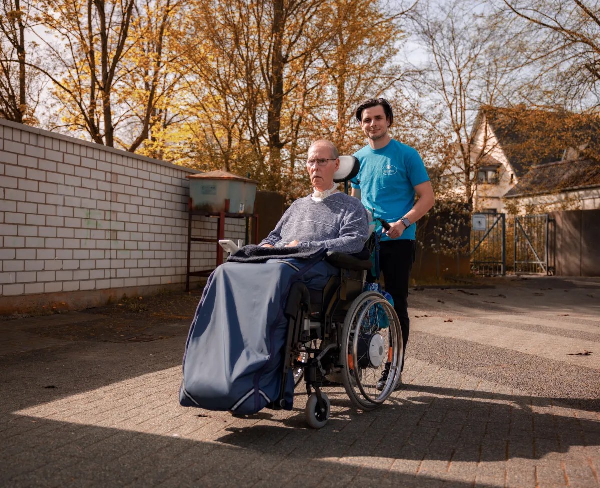 person in red sweater holding babys hand