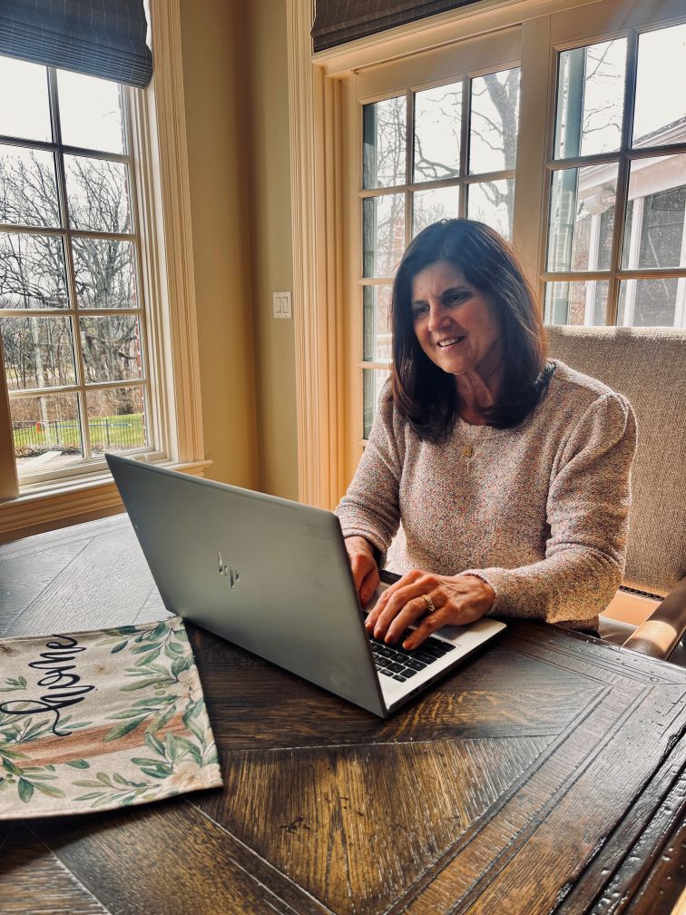 short-haired black cat besides brown wooden table