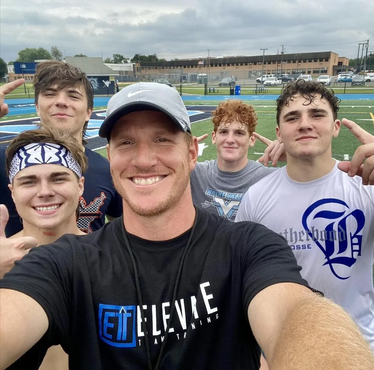 NJ Football players with Coach Wood, showcasing unity, team culture