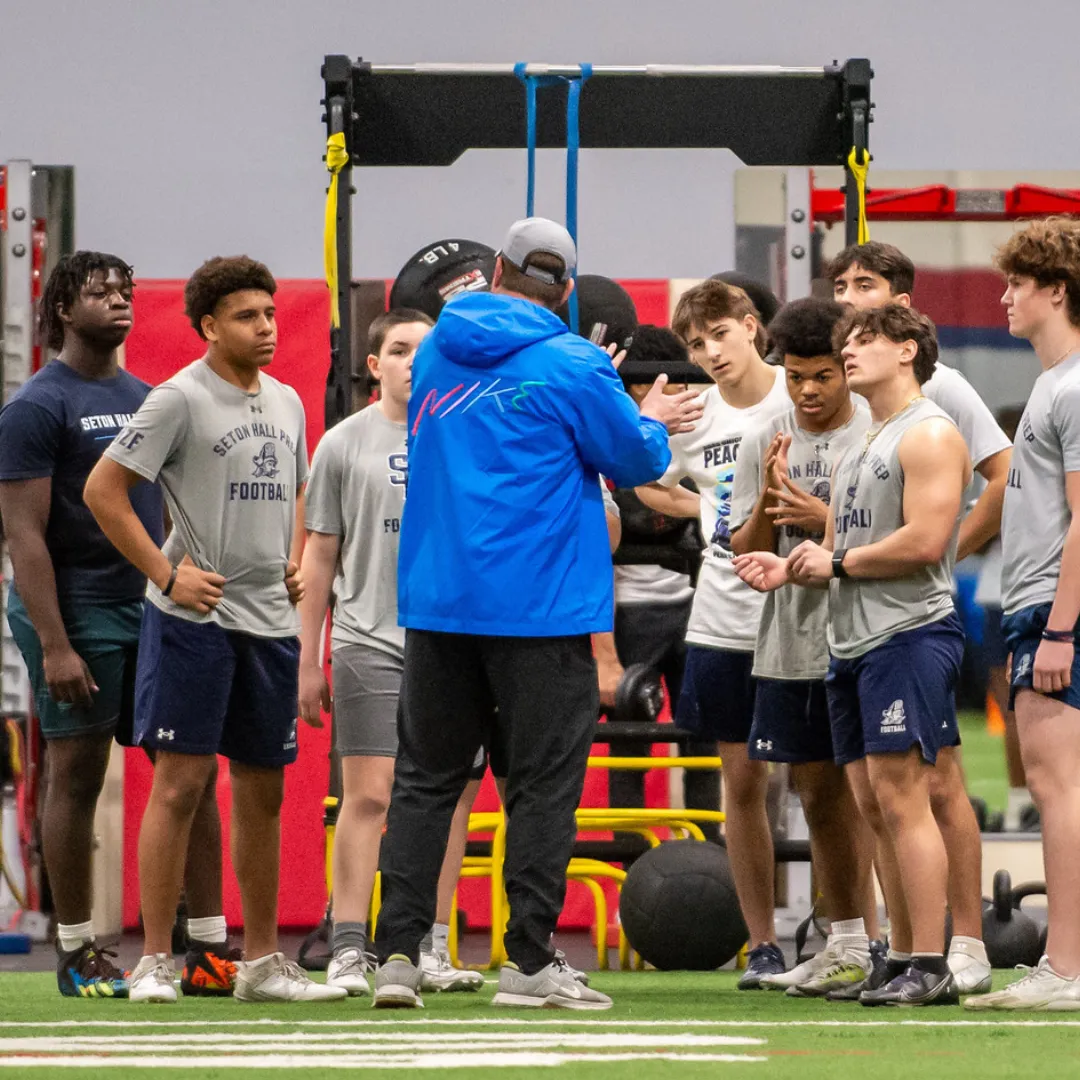 Football athletes receiving coaching, enhancing strategic understanding, skills, and teamwork for superior game performance in New Jersey.