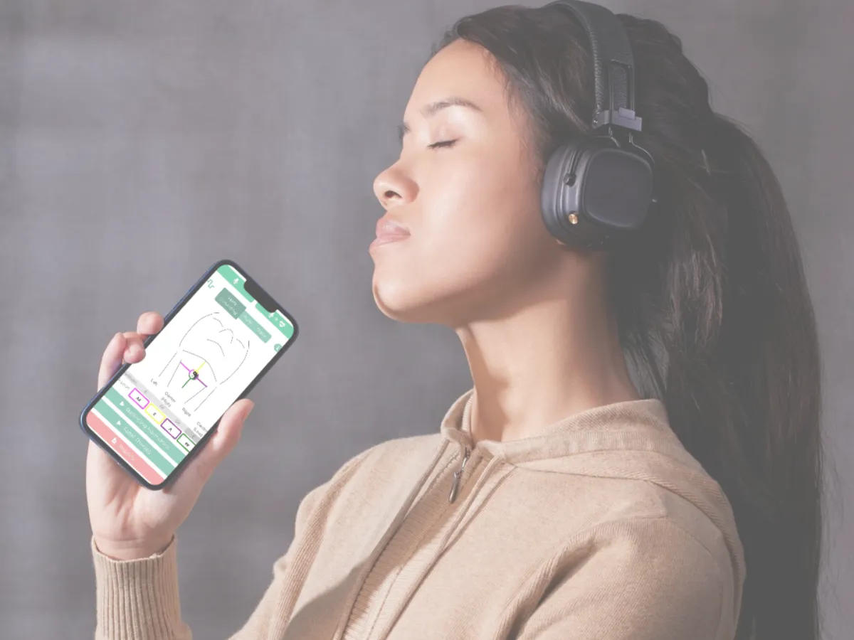 A holistic practitioner gently moves their hands above a relaxed participant lying on a mat, with subtle glowing aura effects. The tranquil studio features lush green plants, crystals, and natural light, creating a peaceful, nurturing environment that emphasizes vibrational healing and energy work.
