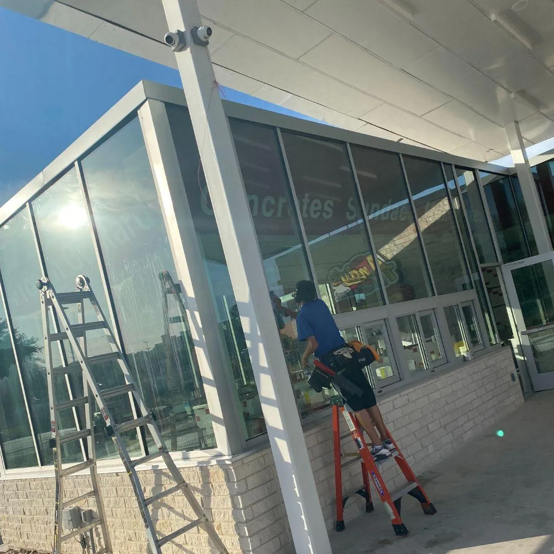 DND window cleaning Commercial window cleaning service San Antonio - expert cleaner working on multi-story glass office building exterior windows