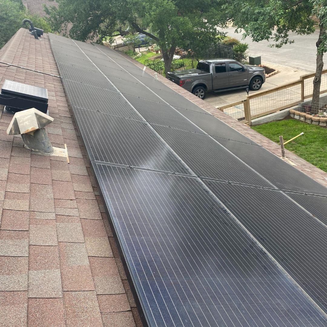 San Antonio roof cleaning results displaying spotless solar panels and pristine brown shingle rooftop after professional service