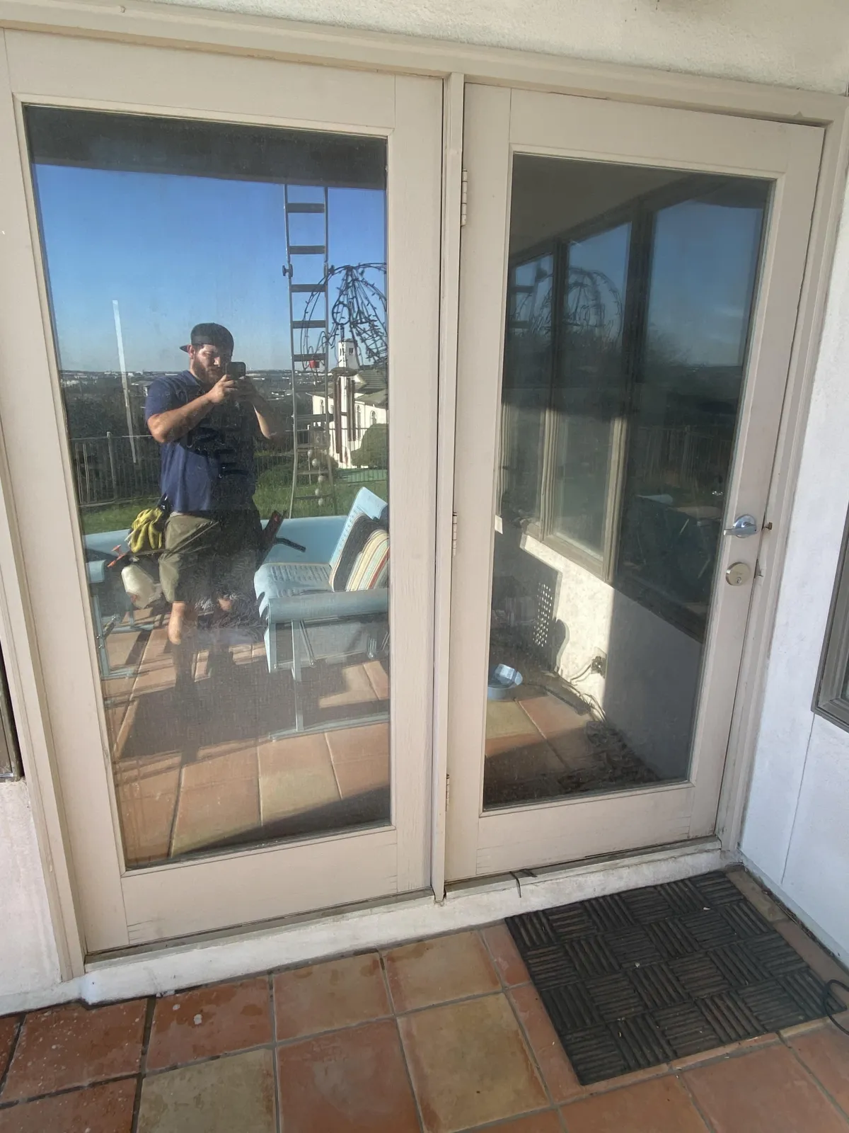 DND Window Cleaning technician cleaning exterior glass doors at a home in San Antonio, Texas.