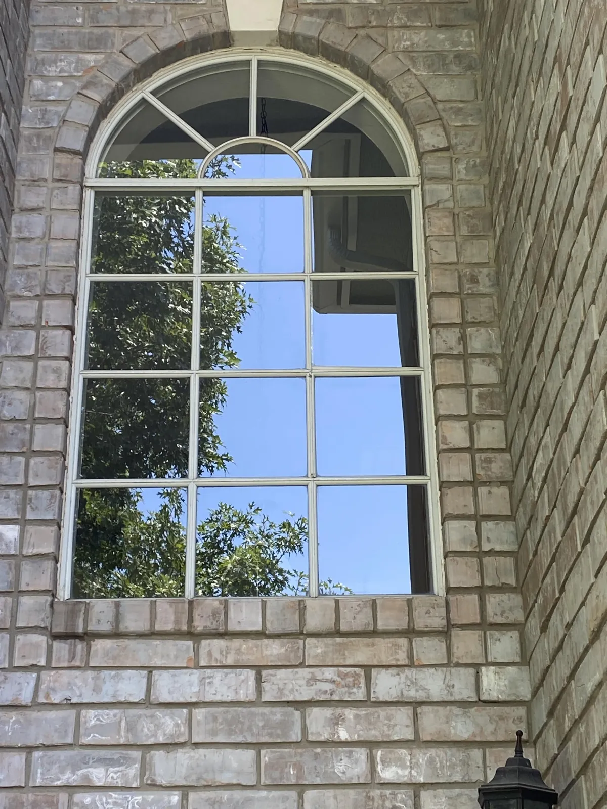 Professional San Antonio window cleaning results showing crystal clear arched residential windows on brick home exterior