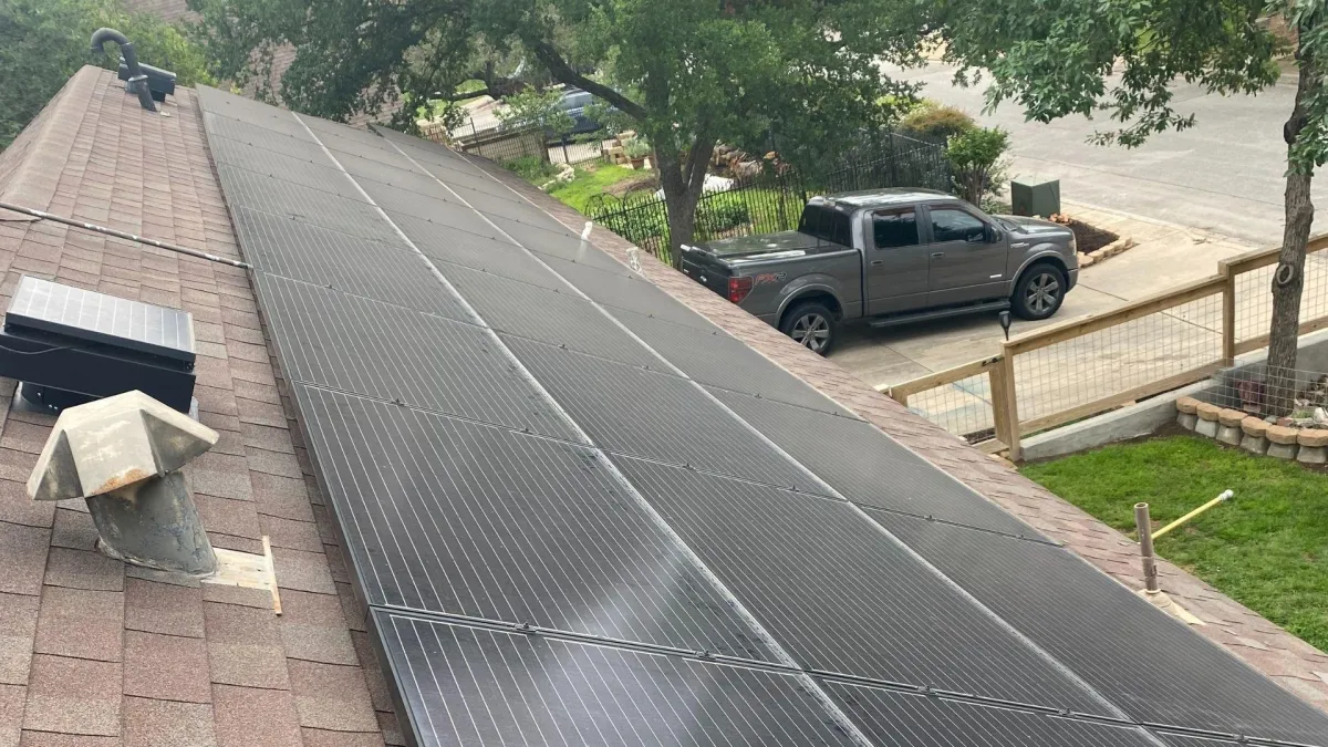 San Antonio roof cleaning results displaying spotless solar panels and pristine brown shingle rooftop after professional service