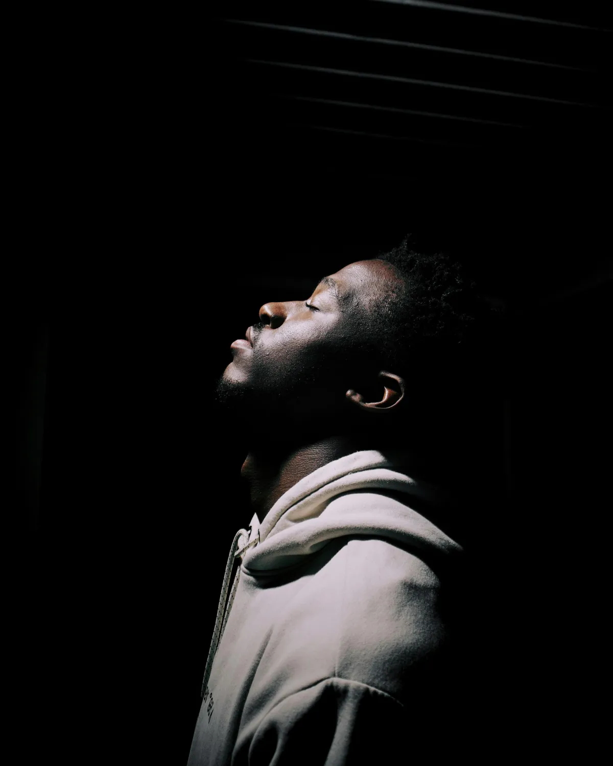 Man lifting his face to the sky in prayer representing faith purpose and spiritual awakening through The God Class