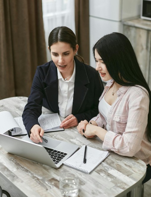 two women meeting and looking at laptop