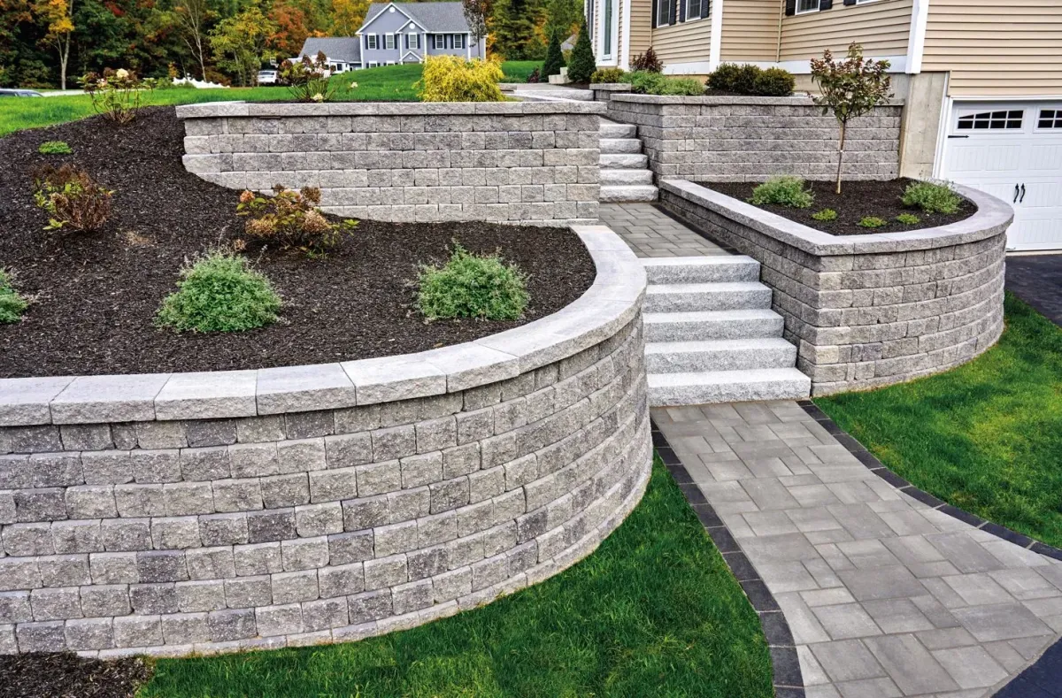 Landscaped outdoor space featuring stone retaining walls, steps, and greenery, showcasing professional landscaping services by Aussie Pergolas & Landscapes in Sydney.