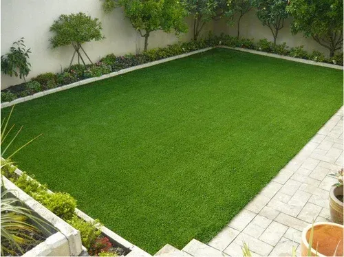 Lush green lawn with manicured edges and surrounding garden beds, showcasing a well-maintained outdoor space ideal for landscaping services in Sydney.