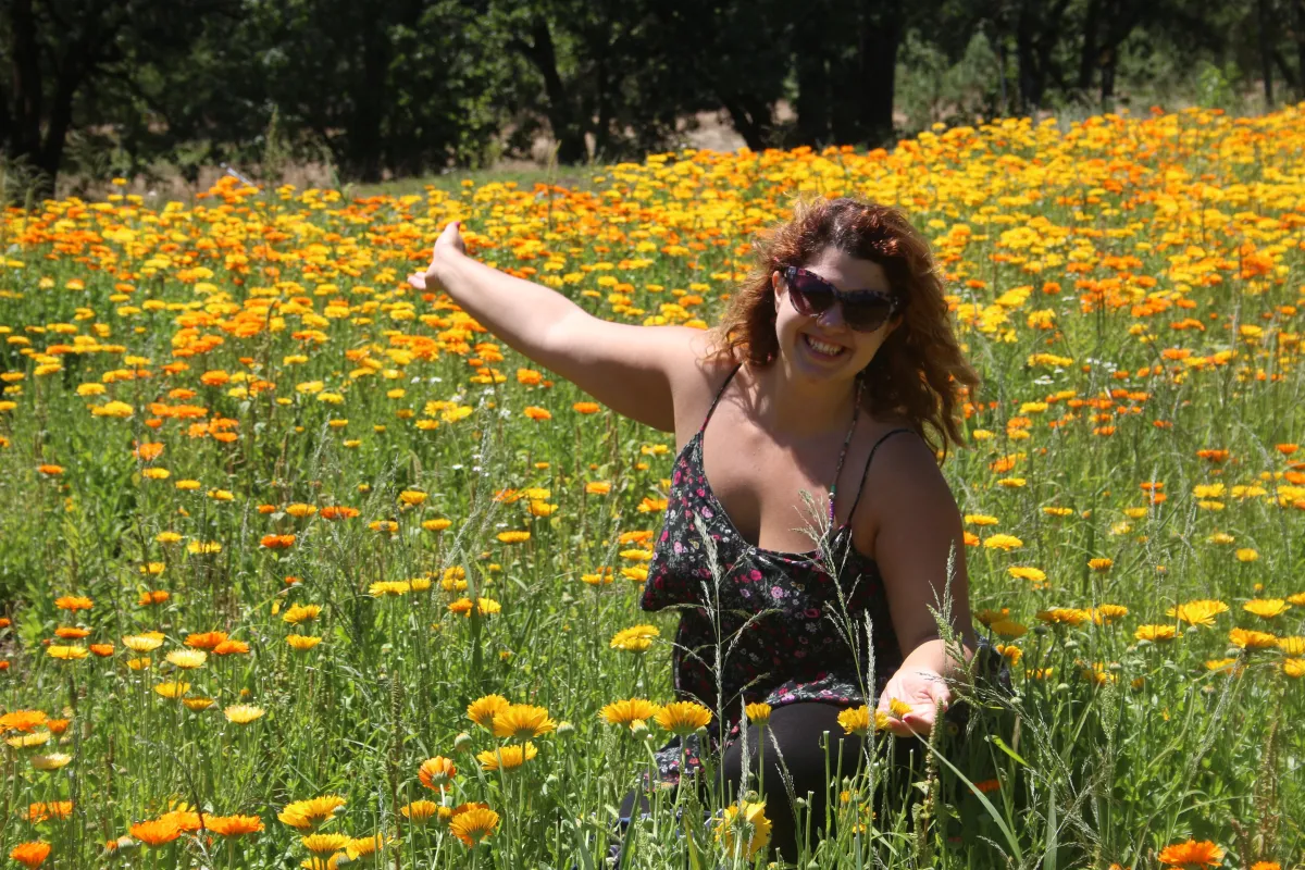 Herbalist Siobhan Carroll looking smiling in a field of Calendula flowers