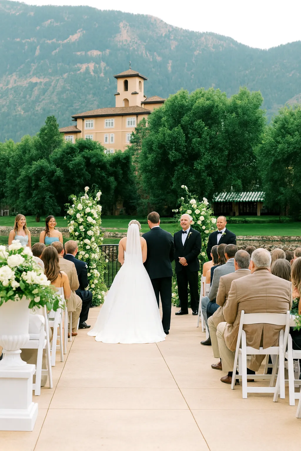 Luxury outdoor wedding ceremony at The Broadmoor in Colorado Springs with bride and groom at the altar, floral arch décor, and mountain backdrop.