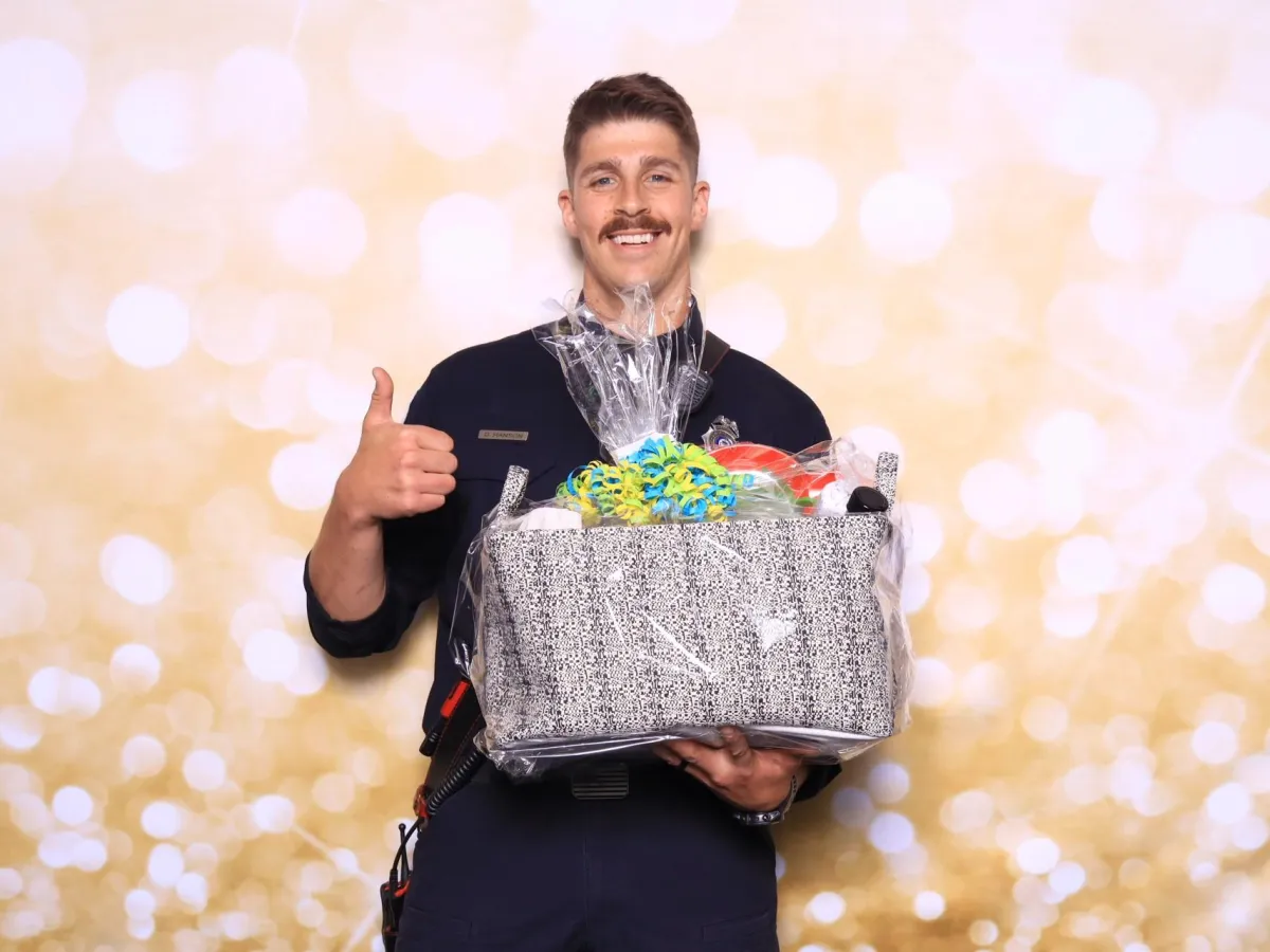 Guest celebrating with prize basket at Bingo, Bags & Heroes fundraiser for Pueblo Crime Stoppers, captured by Martini Moment Photo Booth in Pueblo Colorado