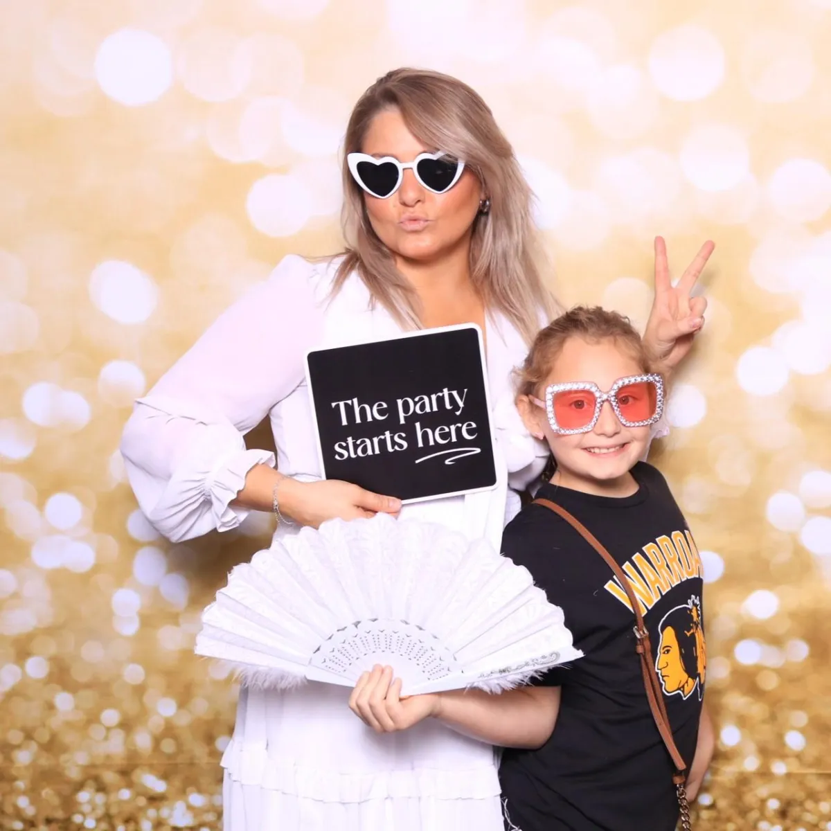 Mother and daughter posing with props in Martini Moment Photo Booth at Bingo, Bags & Heroes community event Pueblo Convention Center