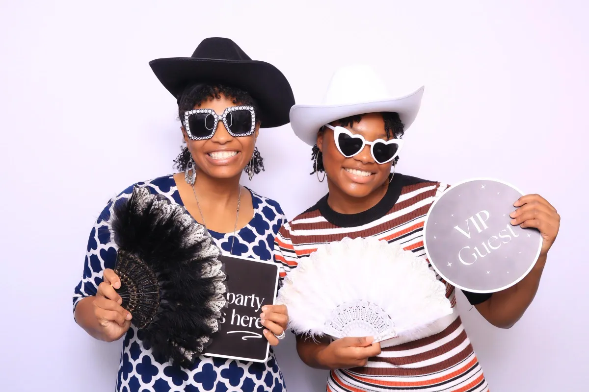 Guests posing with fun props in an elegant photo booth in Colorado Springs