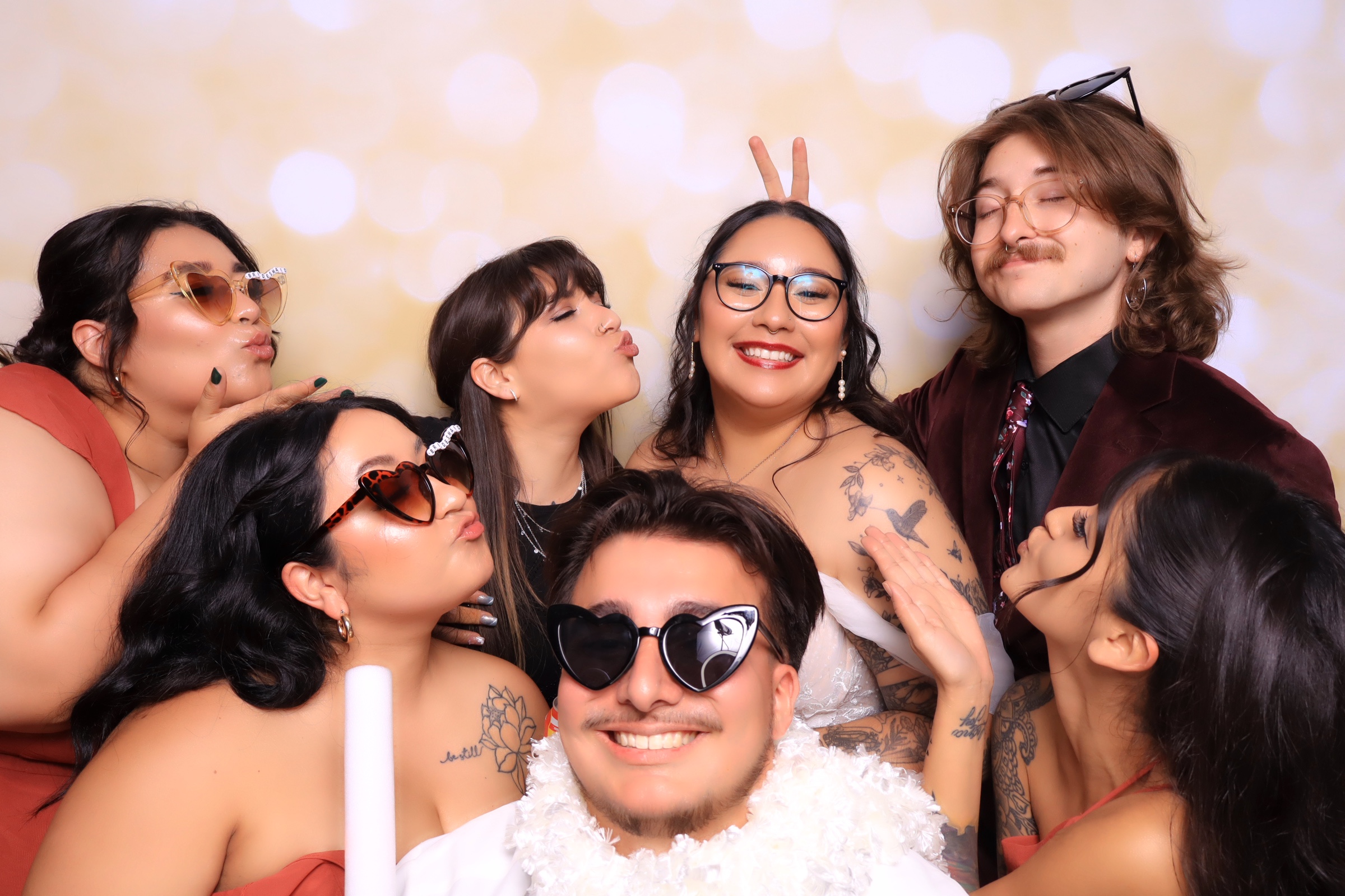 Friends posing in a luxury photo booth with fun props at an elegant real estate broker open event