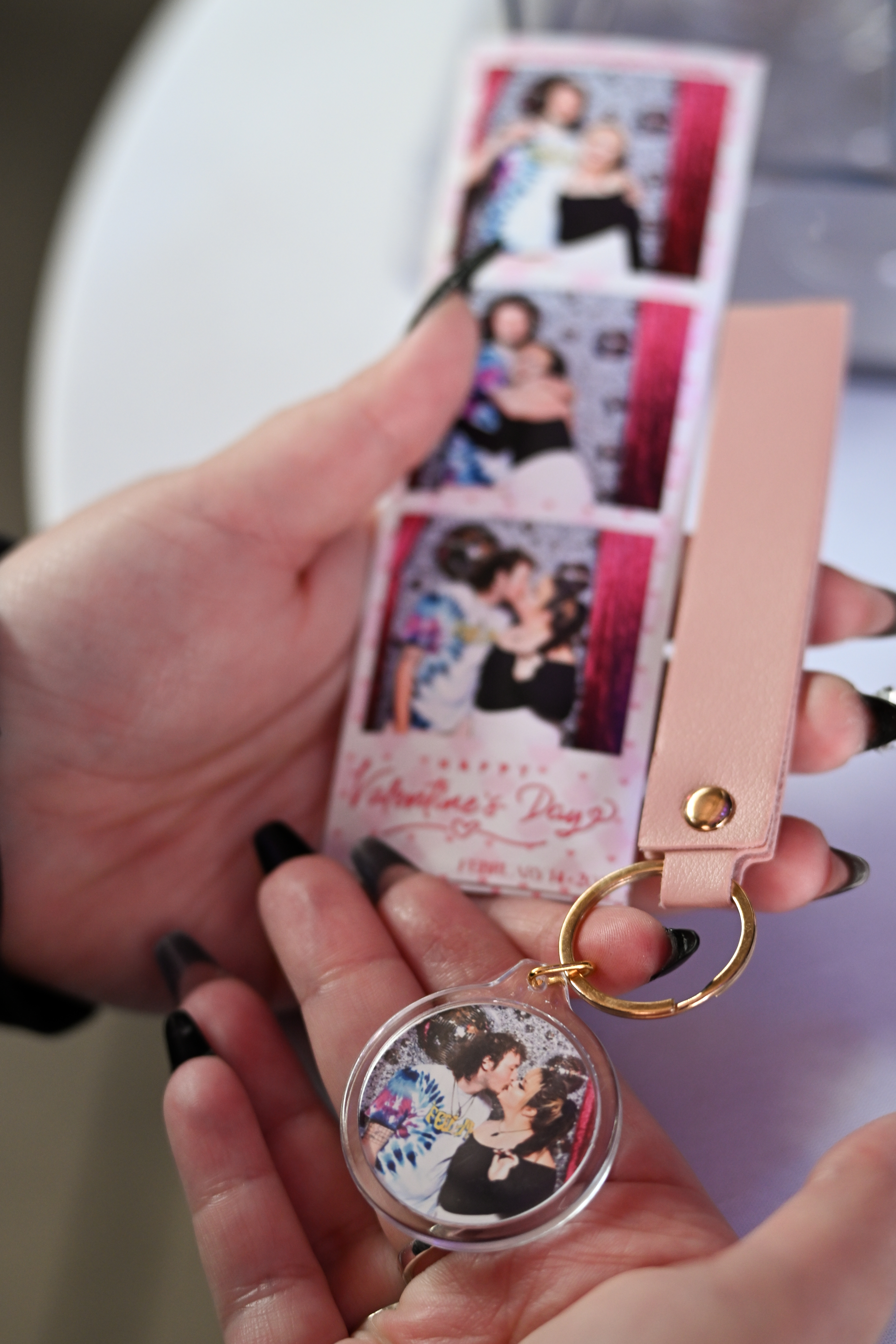 Guest holding a personalized photo keychain made live at a Martini Moment Photo Booth event