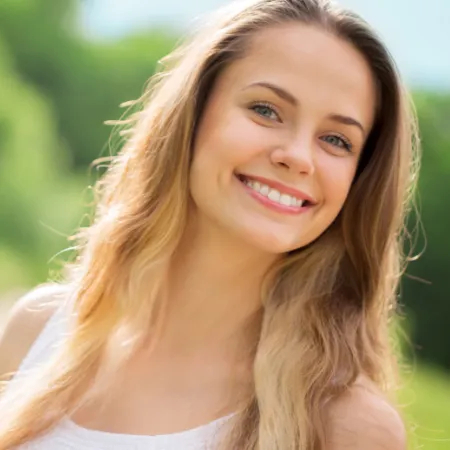 Woman standing outside smiling, posing and looking at the camera