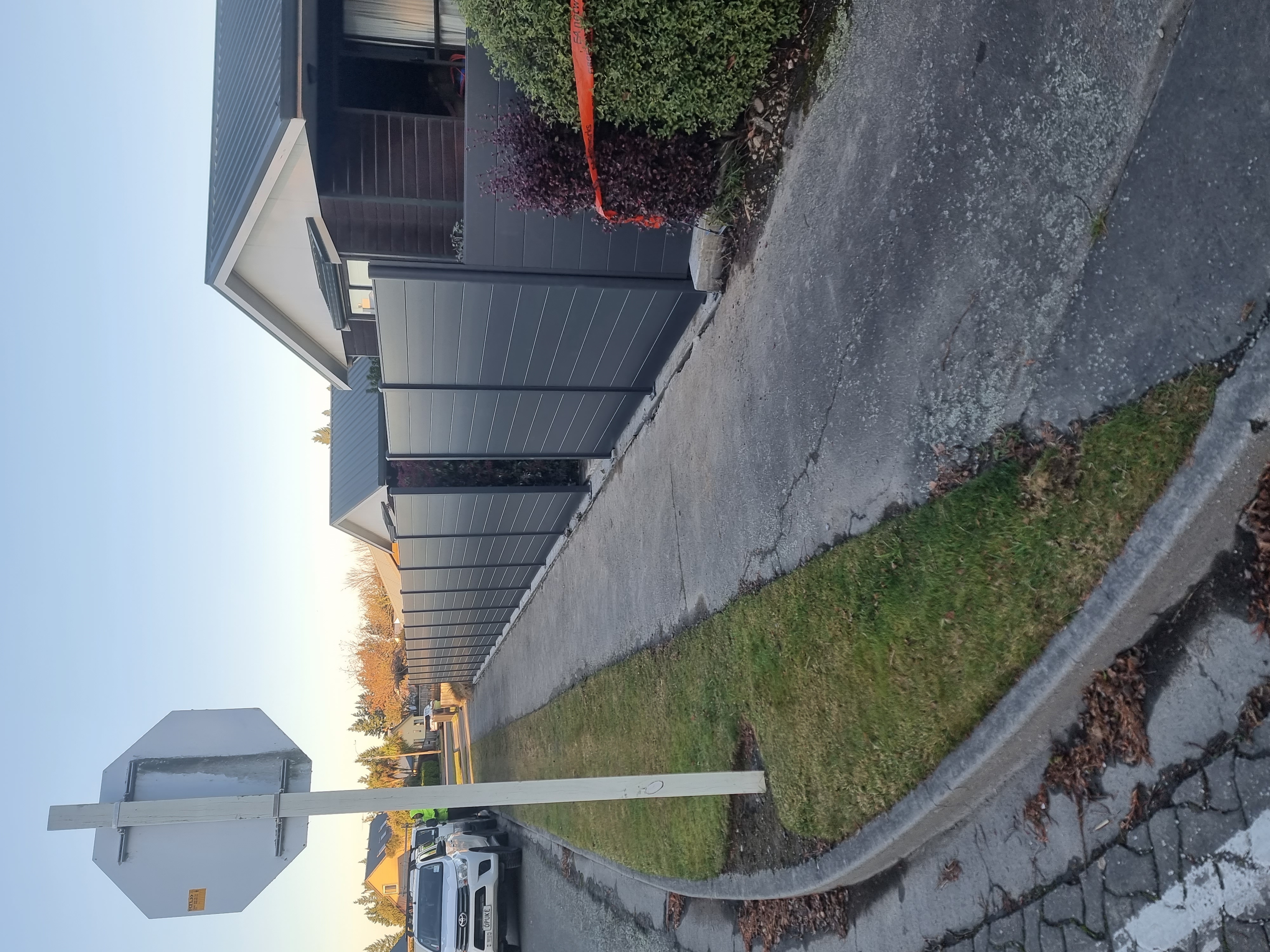 Long dark slat fence along a driveway built by a Methven builder