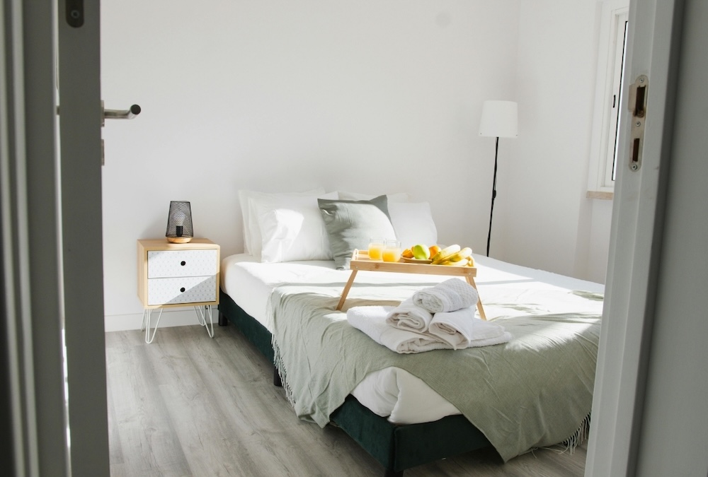 clean short term rental bedroom with fruit lap desk on the bed
