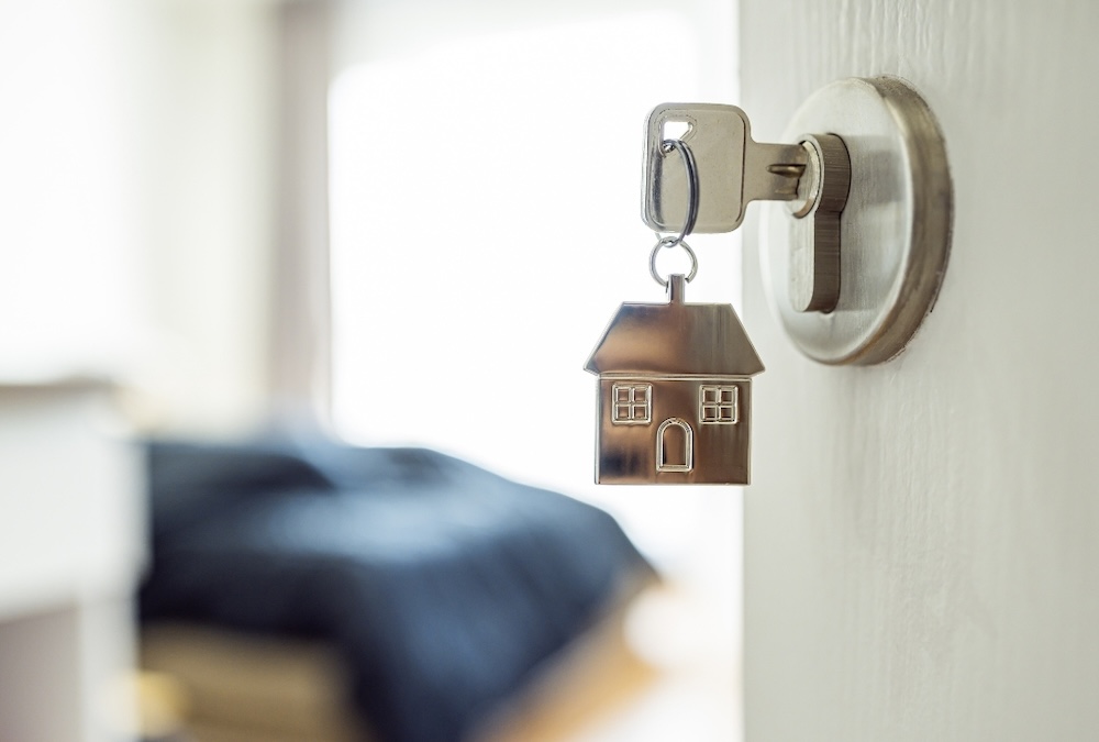 short term rental door knob with a key in the door with a house chain on it