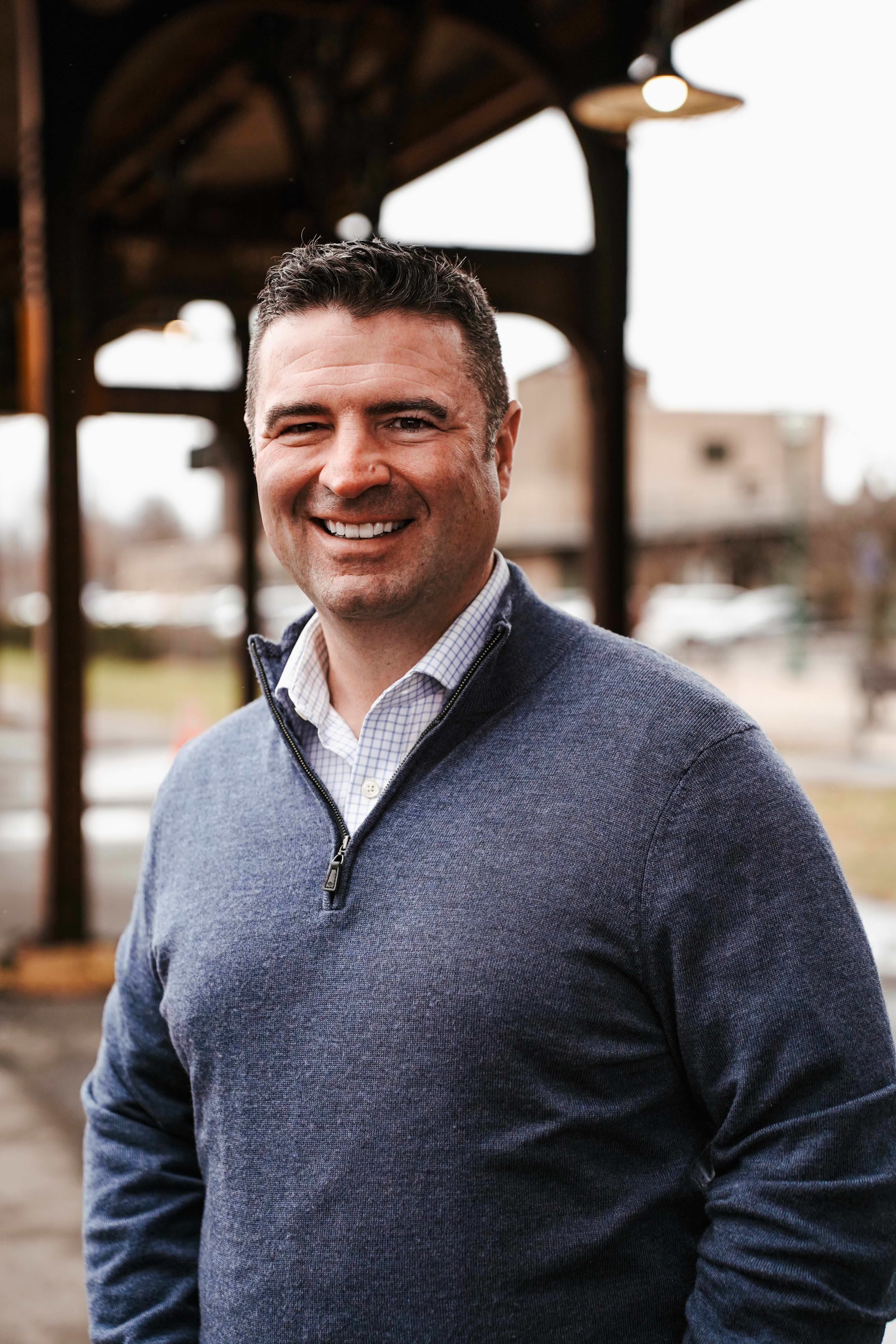 a man standing with his arms crossed in front of a white wall
