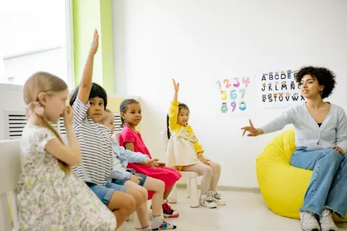 Teacher guiding children during circle time as part of a structured preschool daily routine
