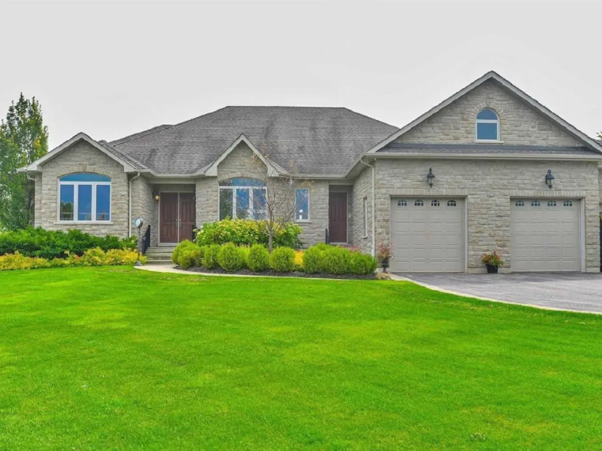 Grey stone bungalow home with attached 2-car garage located in the Brookhaven neighbourhood of East Garafraxa